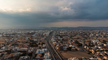 Aerial view of urban landscape with highway and clouds.