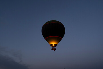 Hot air balloon is on the air at Cappadocia. Silhouette photo at sunrise.