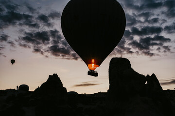 Hot air balloon is on the air at Cappadocia. Silhouette photo at sunrise.