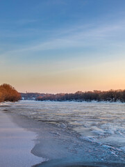 Beautiful, serene scene of a frozen river with a blue sky in the background