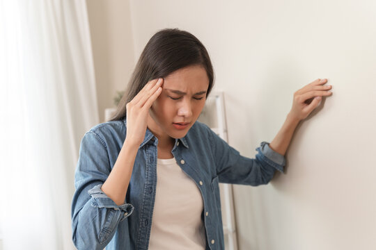 Young Asian females feeling dizzy after standing too fast, have symptoms of low blood pressure
