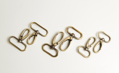 Brass swivel hooks or lobster claw clasps, isolated in white. 