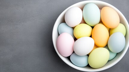 Colorful Easter Eggs in a White Bowl on a Gray Surface Ready for Easter Celebration.