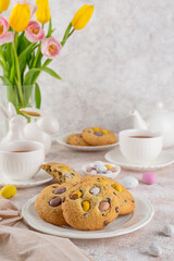 Easter cookies. Tradition american cookies with chocolate mini eggs candy on a white plate. Easter dessert. Copy space.