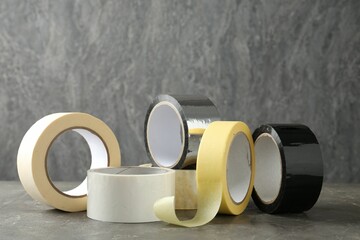 Rolls of different adhesive tapes on grey table