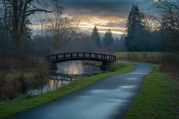 Serene sunset over a park path and bridge.