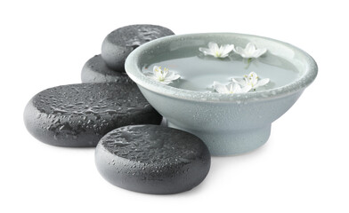 Wet spa stones and bowl of water with beautiful flowers isolated on white