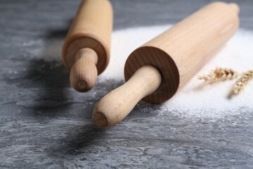 Rolling pins, flour and spikes on grey textured table, closeup