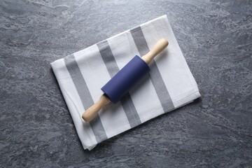 Rolling pin on grey textured table, top view