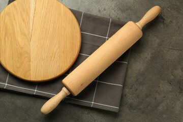 Wooden rolling pin and board on grey table, flat lay