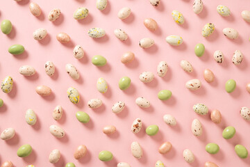 Easter white, green and pink chocolate candy sweets as eggs. Food background. Religion tradition. Abstract pattern. View from above.