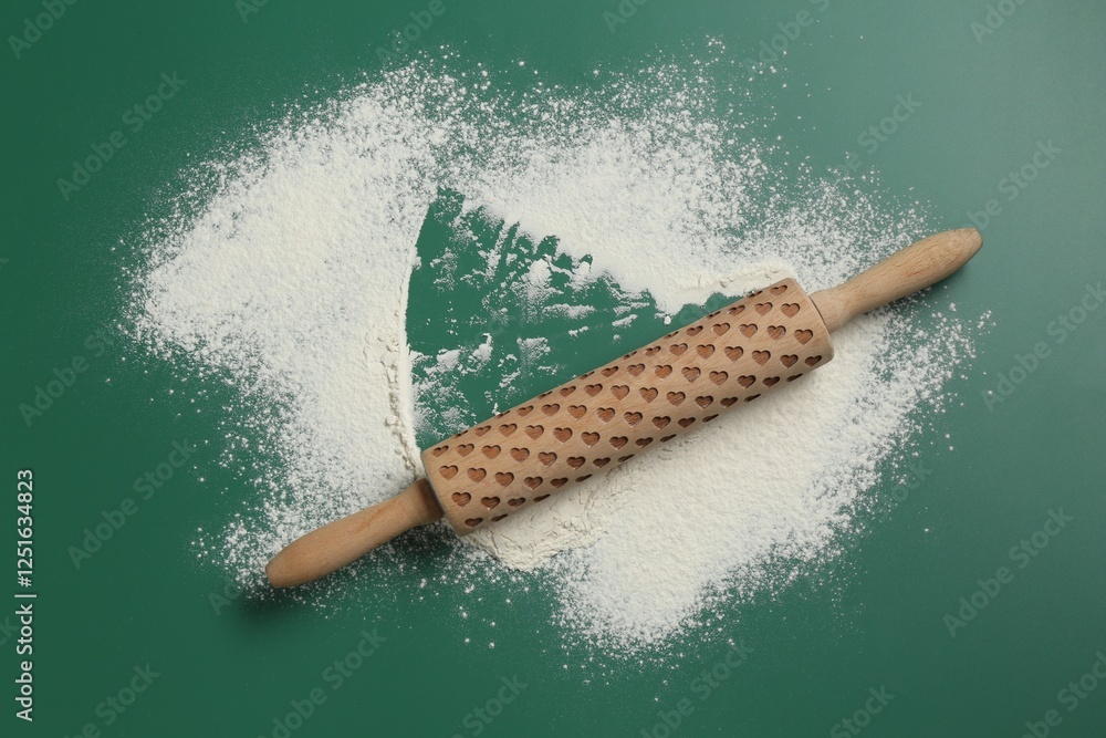 Poster Wooden rolling pin and flour on green background, top view