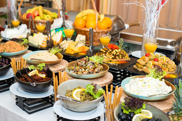 Snacks for the holiday, catering. Various snacks. Assortment of salads and buffet dishes. Meat, fish, cheese, salads, fruits and vegetables, sauces and canapes for celebrating a festive event.