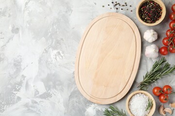 Cutting board with tomatoes and spices on grey textured table, flat lay. Space for text