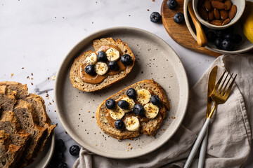 artisanal sourdough toast with almond butter, banana, blueberries, and chia seeds. A healthy, nutritious breakfast ideal for clean eating and balanced diets.
