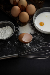 the process of preparing dough with egg, milk, flour and tools for kneading dough on a dark background, different angles