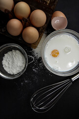 the process of preparing dough with egg, milk, flour and tools for kneading dough on a dark background, different angles