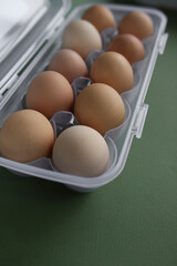 fresh chicken eggs in packaging lie on a green background