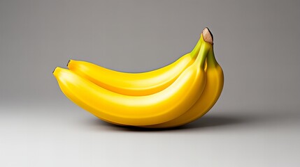 Three ripe yellow bananas arranged on a neutral background.