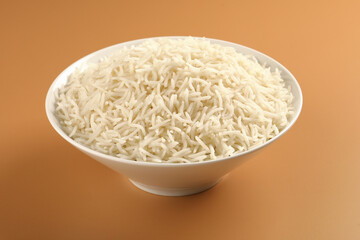 Plain Cooked White Rice in a white Ceramic bowl on orange background