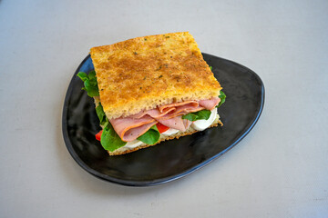 Close-up shot of Izmir's famous Turkish Traditional Kumru Sandwich, Ceşme Kumru, patso ingredients ready to eat salami, soudjouk, tomato, cheddar cheese and fried cheese. Yengen sandvic.