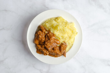 Overhead view of beef goulash with mashed potato