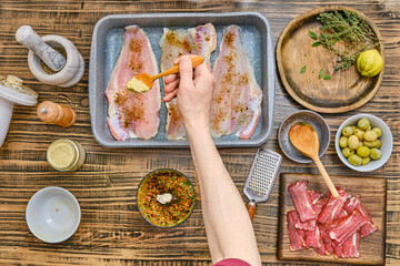 Preparing a flavorful dish with fresh fish and herbs in a cozy kitchen setting