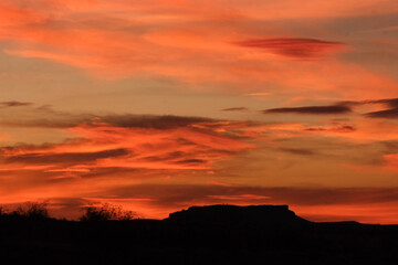 Orange sunset silhouette in the desert mountains © Lauren