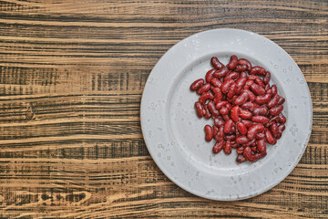 Red kidney beans arranged on a simple plate on a rustic wooden table