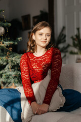 a woman in the Christmas decorated rom with a spruce tree ms Santa