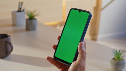 Man browsing sms green screen cellphone at work break in office closeup. 