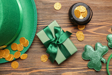 Leprechaun hat with pot of golden coins and gift box on wooden background. St. Patrick's Day