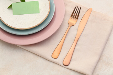 Cutlery and napkin on light background