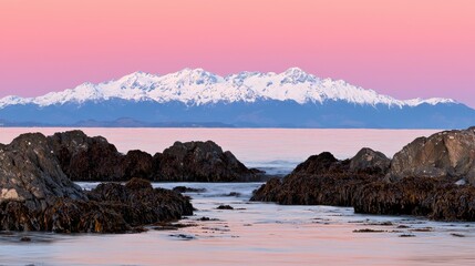 Majestic sunset over snow-capped mountains coastal shoreline landscape photography tranquil ocean wide-angle view nature's beauty