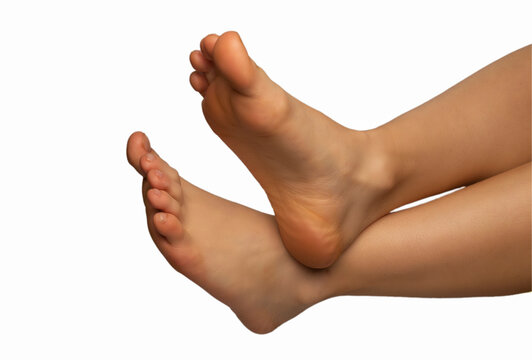 Close-up of female feet on a white background, showcasing miniature, well-toned feet with tightened and exercised shins, highlighting beauty, fitness, and body development.