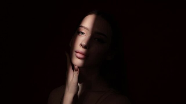 Portrait of attractive girl with healthy clean skin and beautiful make-up. The girl shows her well-groomed skin on her face and neck. Aesthetic cosmetology and makeup concept.