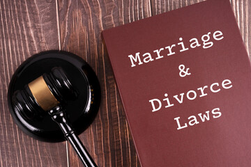Book with MARRIAGE AND DIVORCE LAW written on it. Mallet of the judge with gavel on a wooden table.