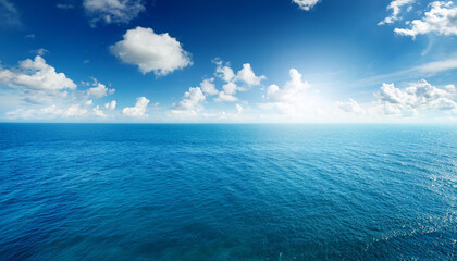 Obraz premium blue sea or ocean with sunny and cloudy sky