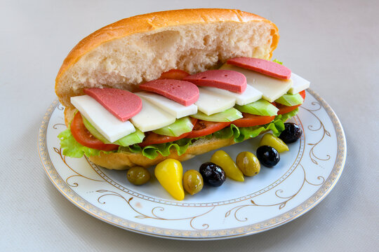 Close-up shot of Izmir's famous Turkish Traditional Kumru Sandwich, Ceşme Kumru, patso ingredients ready to eat salami, soudjouk, tomato, cheddar cheese and fried cheese. Yengen sandvic. Izmir karisik