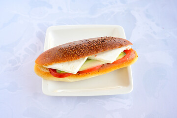 Close-up shot of Izmir's famous Turkish Traditional Kumru Sandwich, Ceşme Kumru, patso ingredients ready to eat salami, soudjouk, tomato, cheddar cheese and fried cheese. Yengen sandvic. Izmir karisik