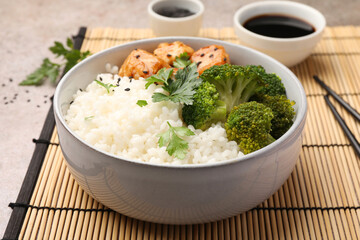 Tasty rice with broccoli and chicken served on grey table, closeup