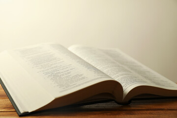 Open Holy Bible in English language on wooden table, closeup
