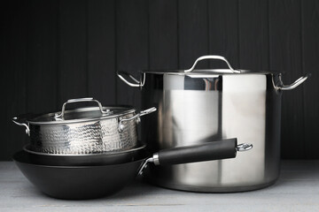 Stainless steel dishware on grey wooden table