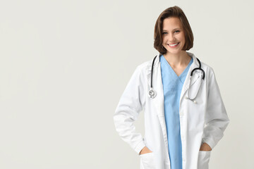 Happy female doctor with stethoscope on white background