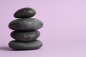 Stack of rocks on lilac background, space for text. Harmony and life balance