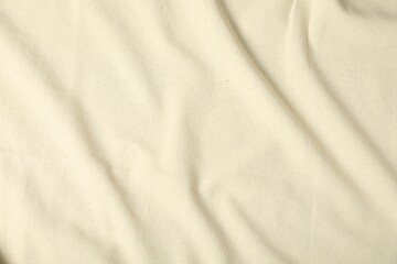 Texture of beige crumpled tablecloth as background, top view