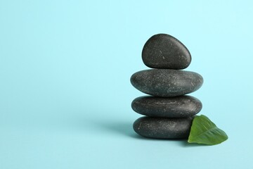 Stack of rocks on light blue background, space for text. Harmony and life balance