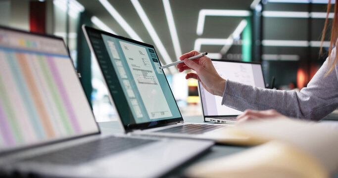 Young female accountant managing e-invoices on laptop