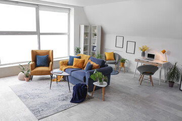 Armchairs and cozy sofa with cushions in living room