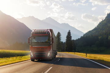 Scenic front view modern white semi-trailer truck driving stunning alpine mountain road warm sunset...